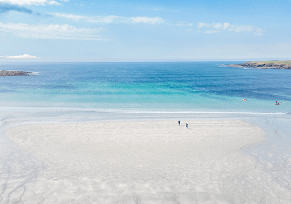 Weiter Sandstrand im hellblauem Wasser auf den Orkney Inseln erinnert an die Südsee.